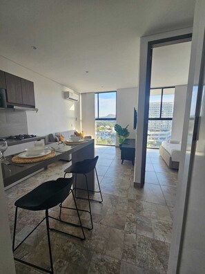 Eine moderne Küche mit Essbereich, Blick auf die Stadt und einem Balkon.