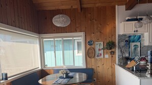 Un interior de madera con una mesa redonda, banco y mostrador de cocina.
