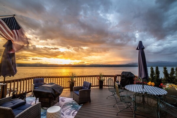 Una terraza con mobiliario exterior, una parrilla y una mesa con mantel estampado.