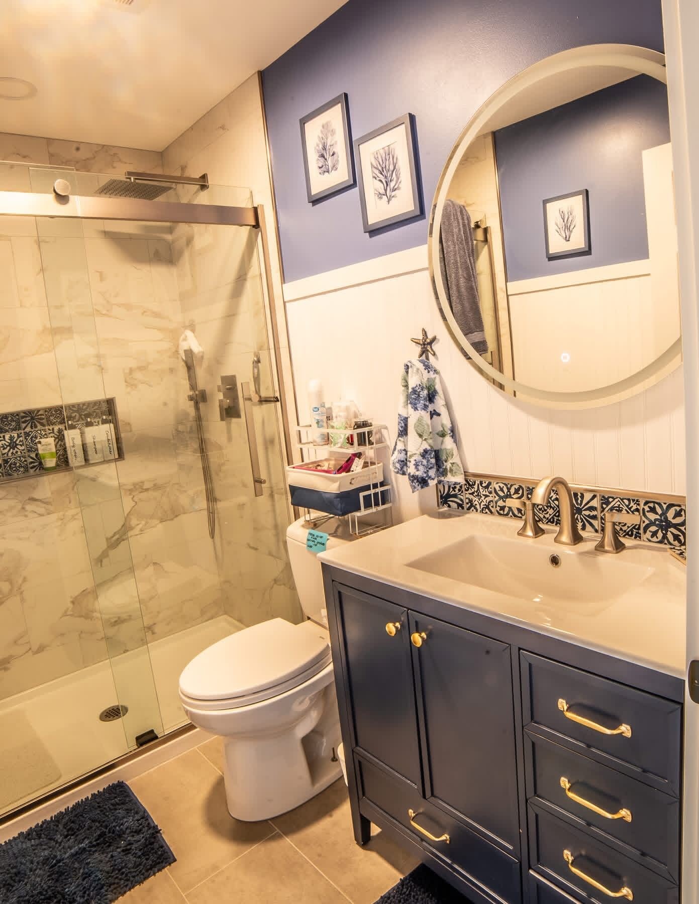Une salle de bain avec une douche à parois de verre, des toilettes, un meuble-lavabo et un miroir.