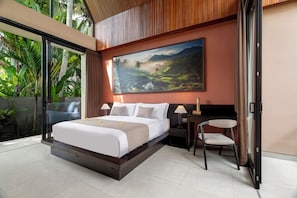 Un dormitorio moderno con una cama grande, un cuadro de un paisaje, una silla y una mesita de noche.