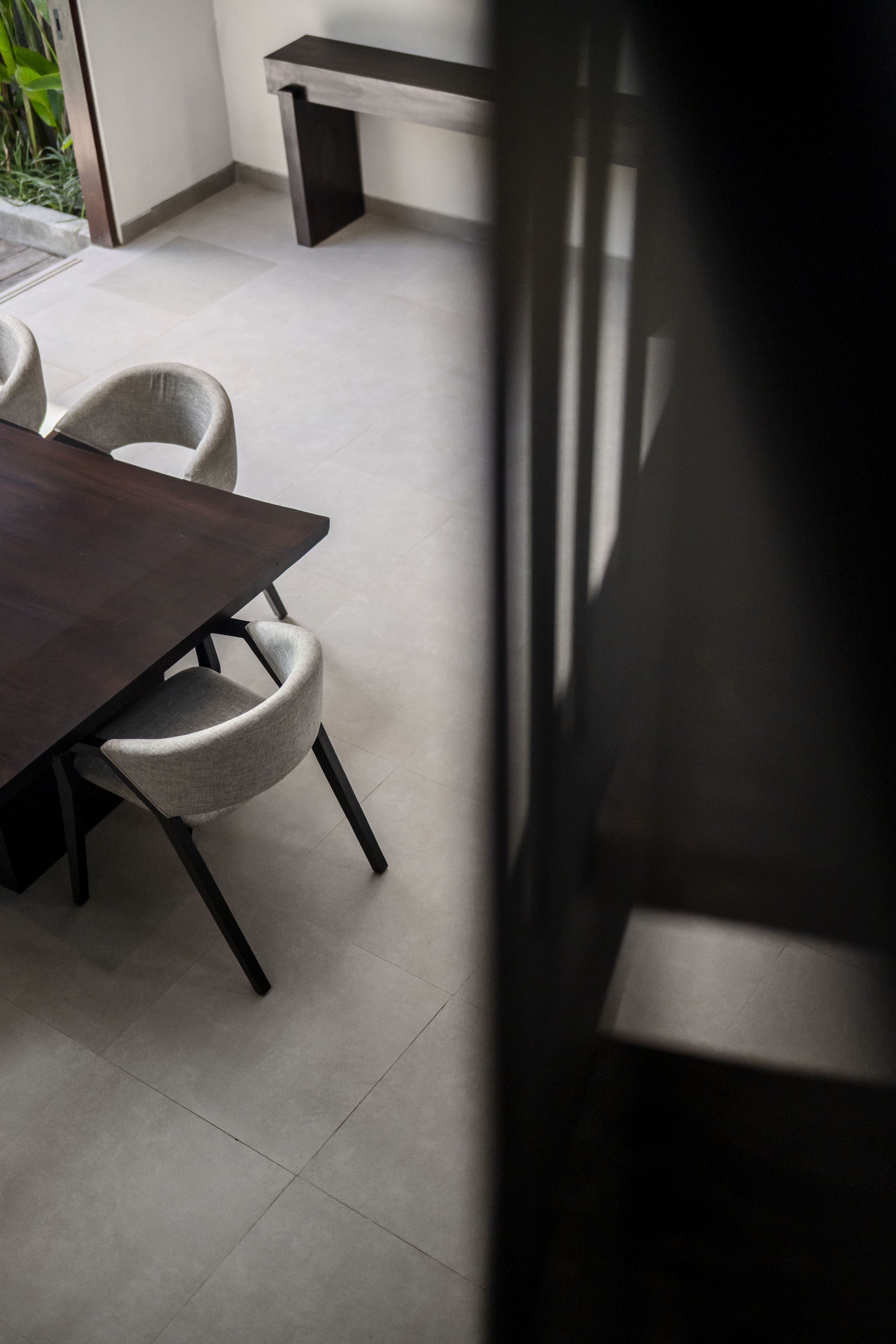 A dining area with a dark wooden table and two upholstered chairs.