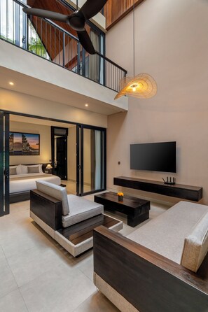 Una sala de estar moderna con un sofá, una mesa de centro y un televisor de pantalla plana montado en la pared.