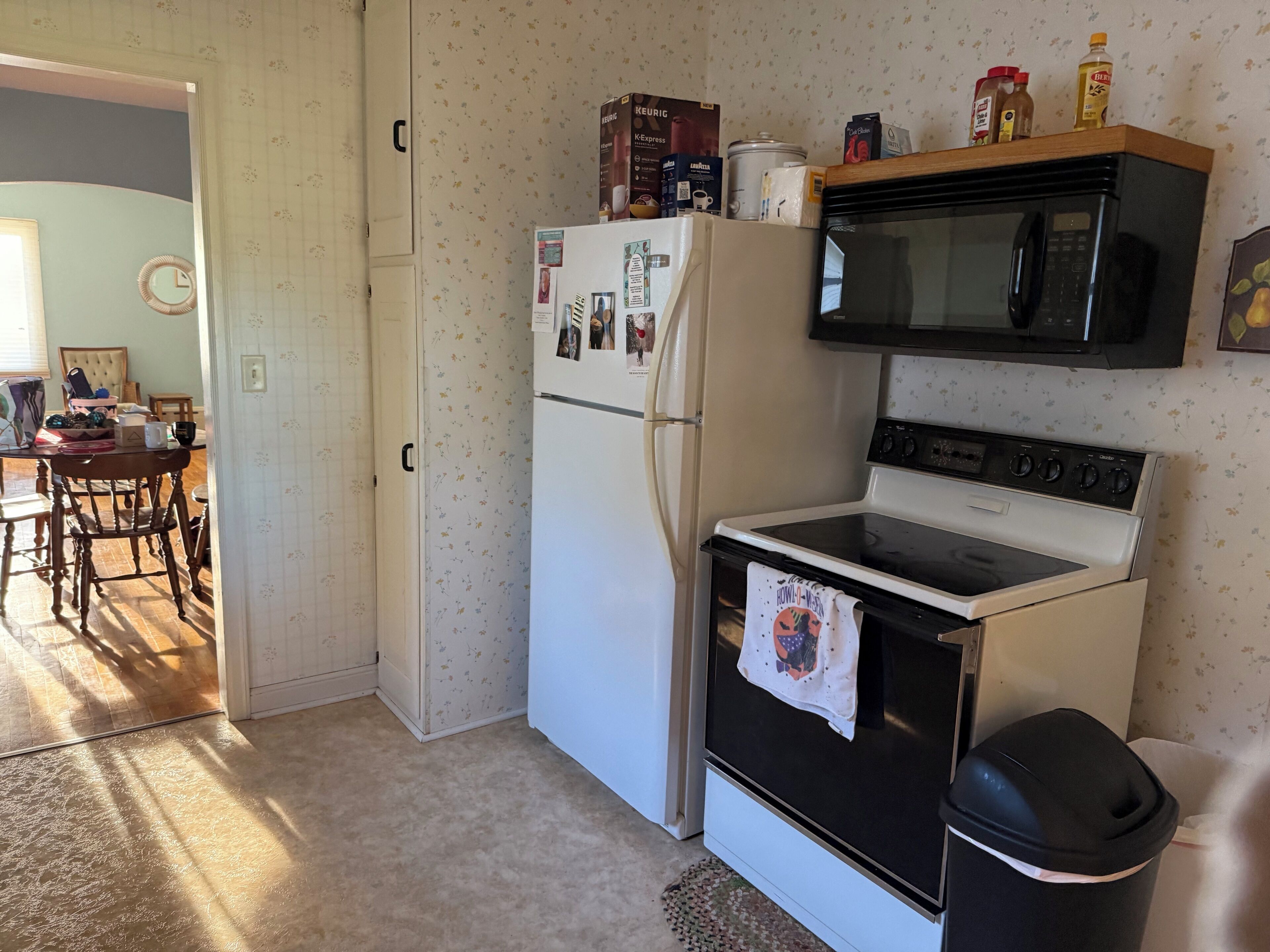 A kitchen with a refrigerator, microwave, and stove.