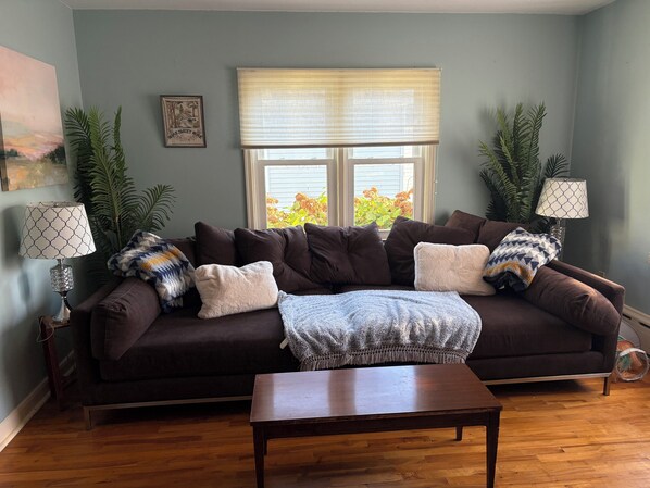 A living room with a dark brown sofa, a wooden coffee table, and two lamps.