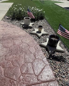 Un sendero pavimentado con macetas en forma de estrella y banderas estadounidenses.