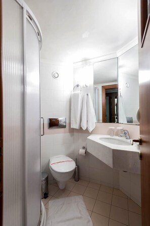Un baño con inodoro, lavabo y ducha.