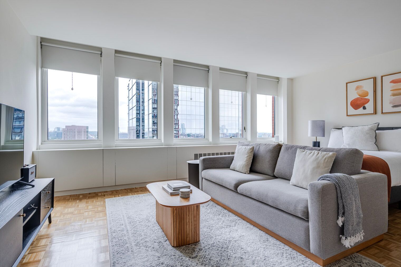 A modern living room with a sofa, a coffee table, and a TV.