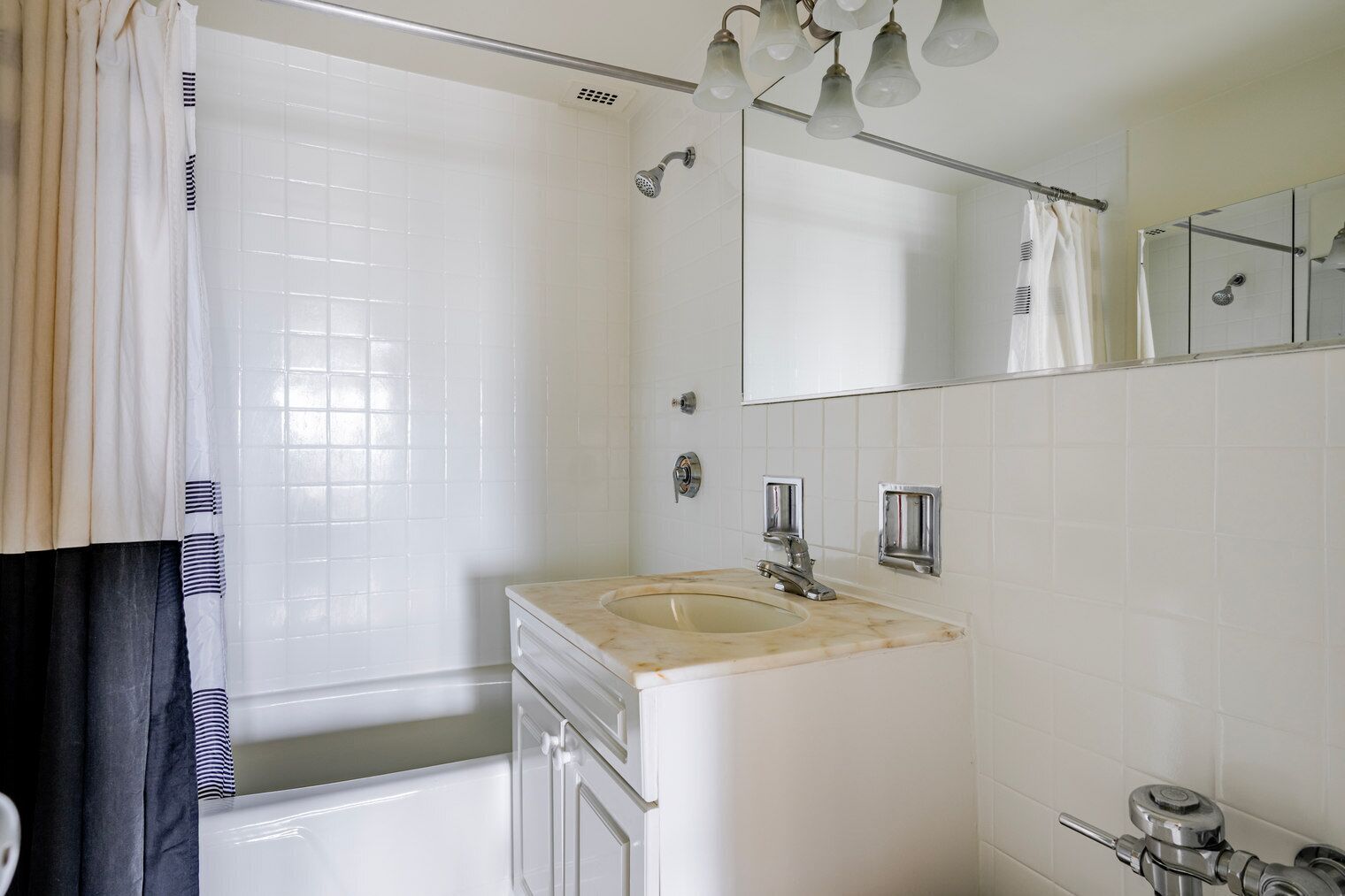 Un baño con bañera, lavamanos, ducha y espejo.