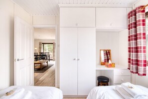 A bedroom with two beds, a desk, a chair, and a wardrobe. - The Raven (Crianlarich)