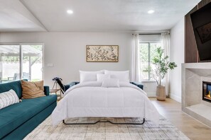 A bedroom with a bed, a sofa, a fireplace, and a window. - Vegas 3BR Pool Retreat · Sleeps 10 · Putting Green · Shuffleboard (Las Vegas)