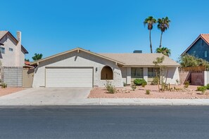 A single-story house with a garage, a small arched entryway, and a number '3706' on the wall. - Vegas 3BR Pool Retreat · Sleeps 10 · Putting Green · Shuffleboard (Las Vegas)