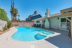 A swimming pool with a sunken hot tub, lounge chairs, and a house with a tiled roof. - Vegas 3BR Pool Retreat · Sleeps 10 · Putting Green · Shuffleboard (Las Vegas)