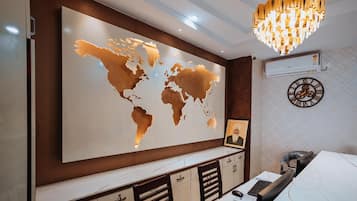 A modern office space with a large world map on the wall, a desk with a computer, and a decorative clock.