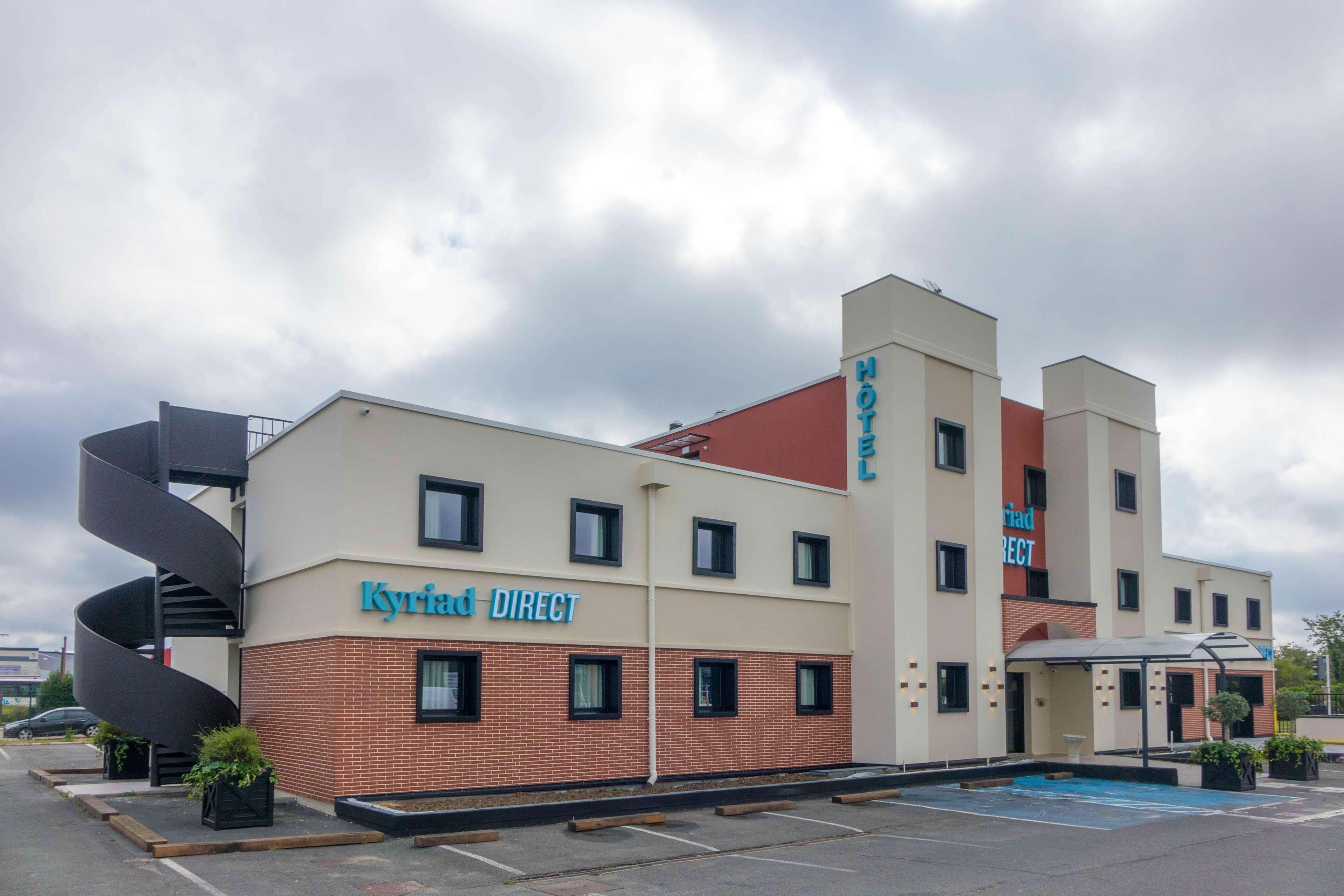 A hotel named 'Kyriad DIRECT' with a modern design, featuring a prominent spiral staircase and a swimming pool.