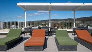 Un espace de détente aménagé sur le toit, avec des meubles d’extérieur et une vue sur le paysage.