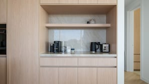 A compact kitchen with a marble backsplash, a coffee maker, a toaster, and a kettle. - SeaView Penthouse at Dromana Beach (Dromana)