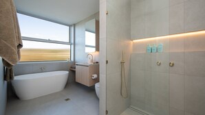Une salle de bain moderne avec une baignoire sur pieds, une douche et une fenêtre offrant une belle vue.