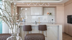 A modern kitchen with a marble countertop, two bar stools, and a built-in oven. - SeaView Penthouse at Dromana Beach (Dromana)