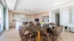 A modern kitchen with a central island, a dining area with a marble table, and leather chairs. - SeaView Penthouse at Dromana Beach (Dromana)