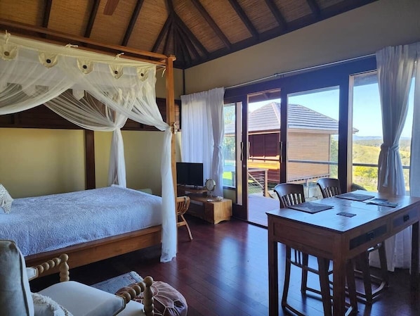 A room with a bed, a desk, and a dining table.