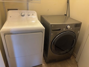 A compact laundry area with a front-loading washer and dryer. - 2-bedroom/ 3 bed condo at SouthPadre Island (South Padre Island)