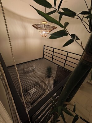 A room with a bed, a hanging light fixture, and a plant. - Pool-Vacation-Jobs-Grills - PUERTO CARMA (Las Juntas)