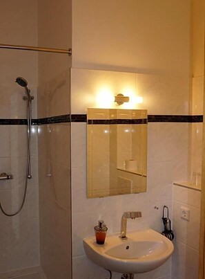A bathroom with a shower, a sink, and a mirror. - Landgasthof Waabs Mvºhle (Waabs)