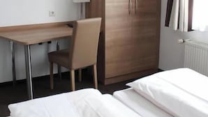 Une chambre d’hôtel comprenant un lit, un bureau, une chaise, une armoire et un téléviseur.
