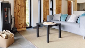 Un salon moderne avec une cheminée, un canapé et une table basse.