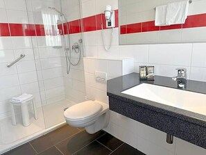 A modern bathroom with a shower, toilet, and sink. - Hotel Restaurant Thum (Balingen)