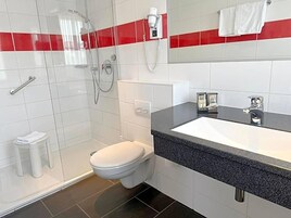 Un baño moderno con ducha, inodoro y lavamanos.