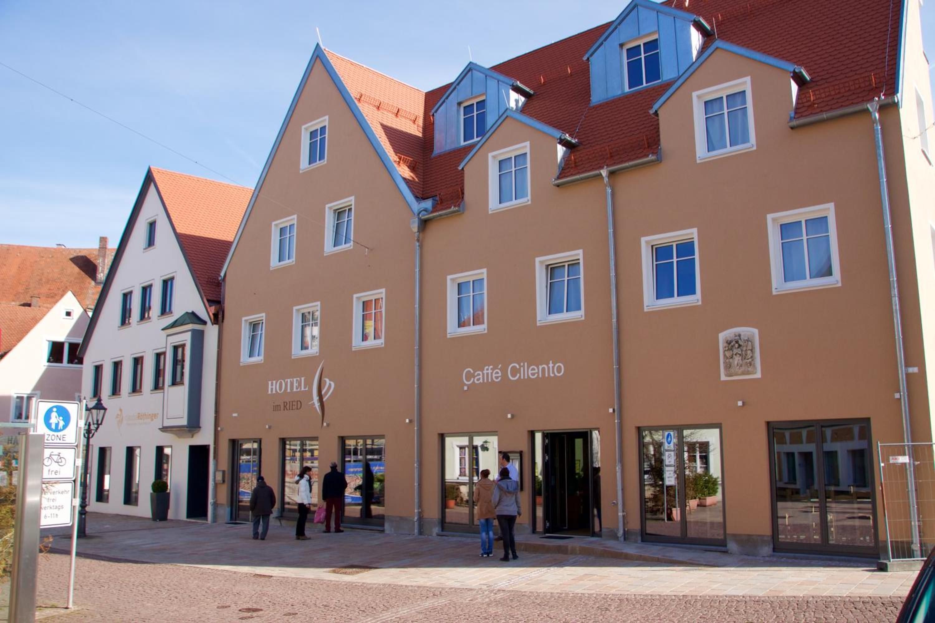Un hotel con arquitectura europea tradicional, que presenta una entrada central con puertas de vidrio y un cartel que indica que es un hotel.