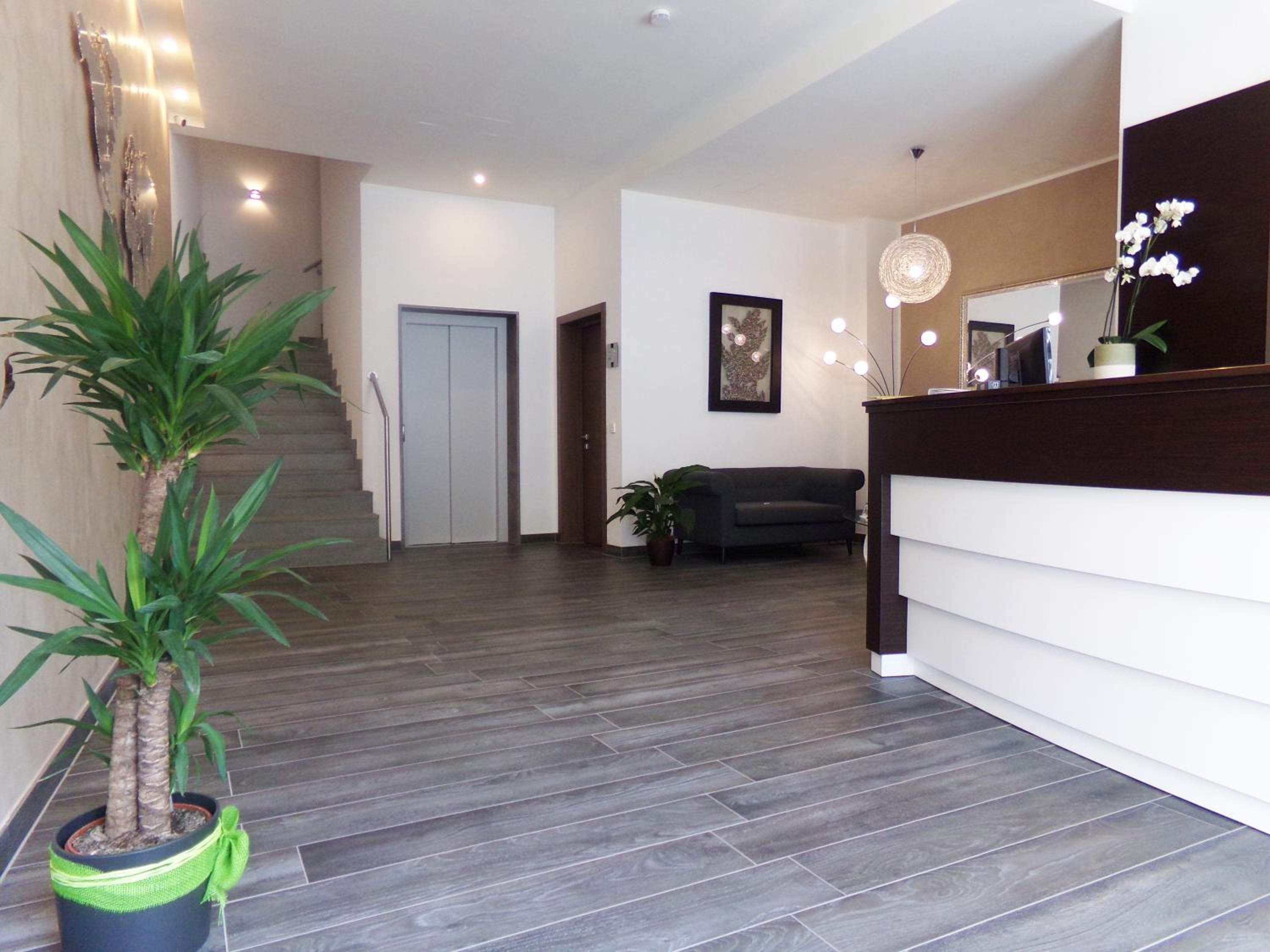 Ein modernes Interieur mit einer Treppe, einem Empfangstresen und einem Sofa.