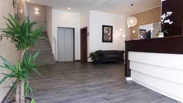 Ein modernes Interieur mit einer Treppe, einem Empfangstresen und einem Sofa.