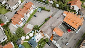 Luchtbeeld van een woonwijk met meerdere huizen, een hoofdstraat en een parkeerplaats.