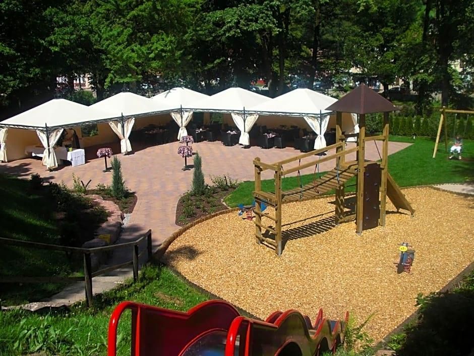 A playground with a slide, climbing structure, and picnic area with white canopies.