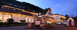 Ein Hotel im traditionellen europäischen Baustil, bestehend aus einem Hauptgebäude mit Satteldach und einem Anbau.