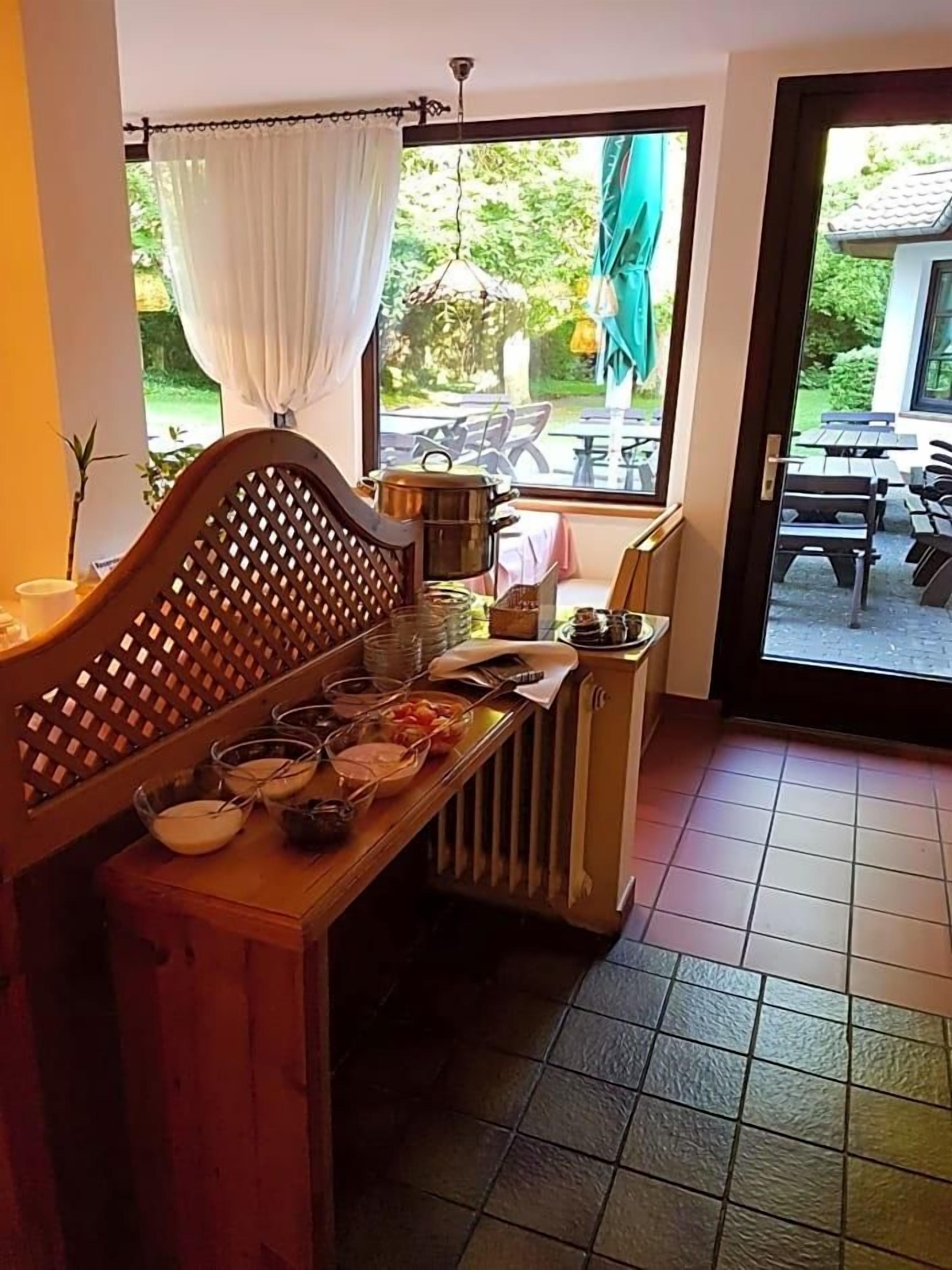 Ein Zimmer mit einer hölzernen Bank, einem Heizkörper und einem Fenster mit Blick auf Gartenmöbel.