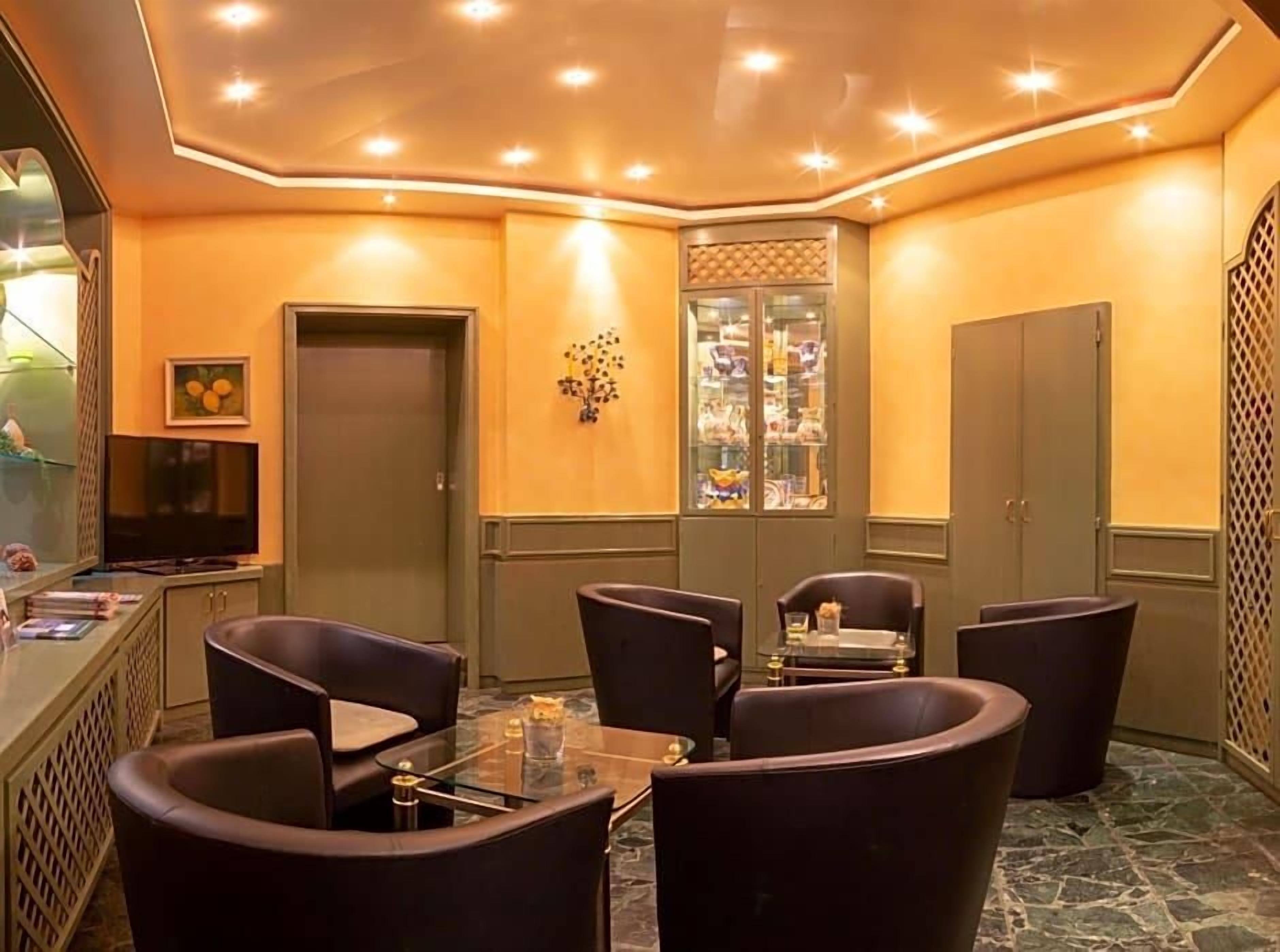 A conference room with a glass table and dark chairs, a television, and a decorative wall piece.