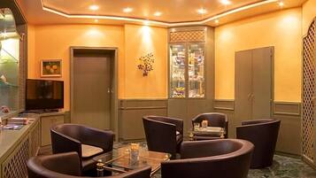 A conference room with a glass table and dark chairs, a television, and a decorative wall piece.