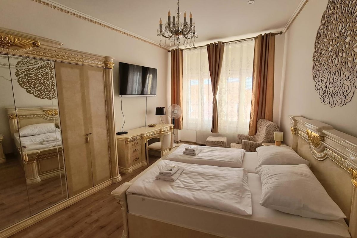 Una habitación de hotel con una cama grande, un escritorio, una silla, un televisor y un espejo.