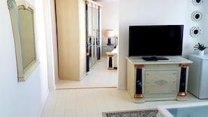 Una sala de estar moderna con un televisor de pantalla plana, un sofá y una mesa de centro.