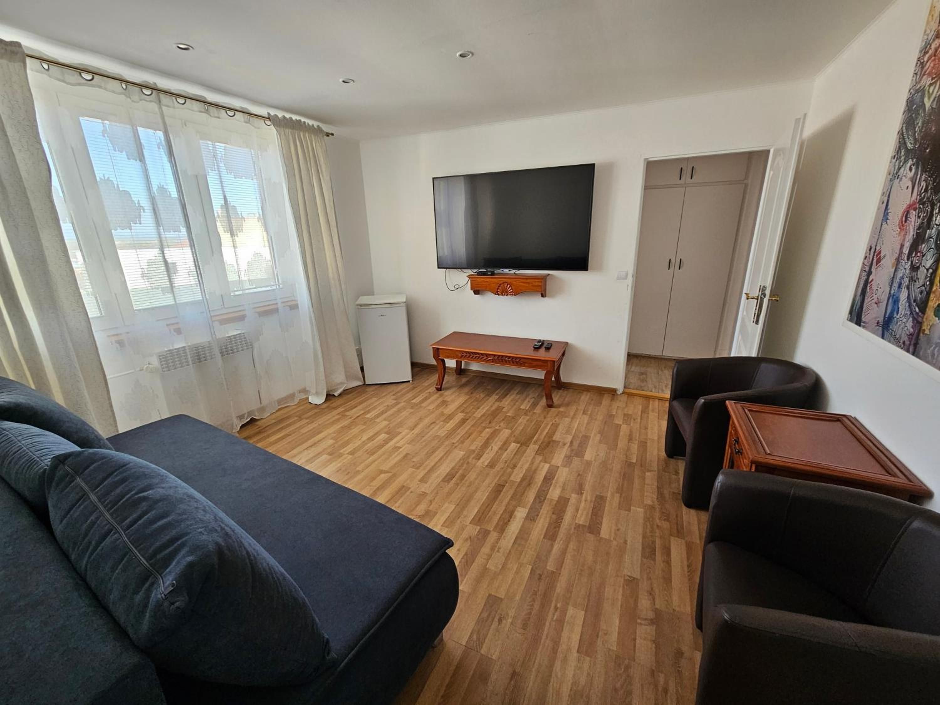 A furnished living room with a sofa, a coffee table, a TV, and a cabinet.
