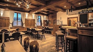 Ein rustikales Interieur mit Holzbalken, einer Bar und einem Essbereich.