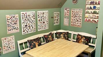 A dining area with a wooden table and benches, surrounded by educational posters on wildlife and minerals.