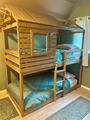 Un lit superposé avec une structure en bois, une échelle et une décoration en forme de papillon.