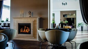 Un interior moderno con chimenea, zona de estar y vista hacia un comedor.