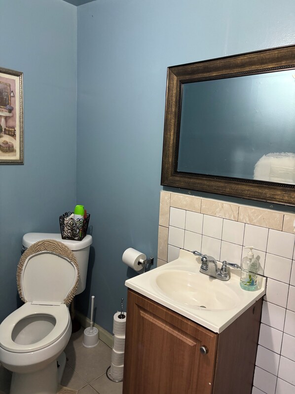 A bathroom with a toilet, sink, and mirror. - 1 bedroom w/yard Einstein Hospital (Philadelphia)