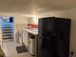 A compact kitchen with a black refrigerator, a stove, a sink, and a dish rack. - 1 bedroom w/yard Einstein Hospital (Philadelphia)